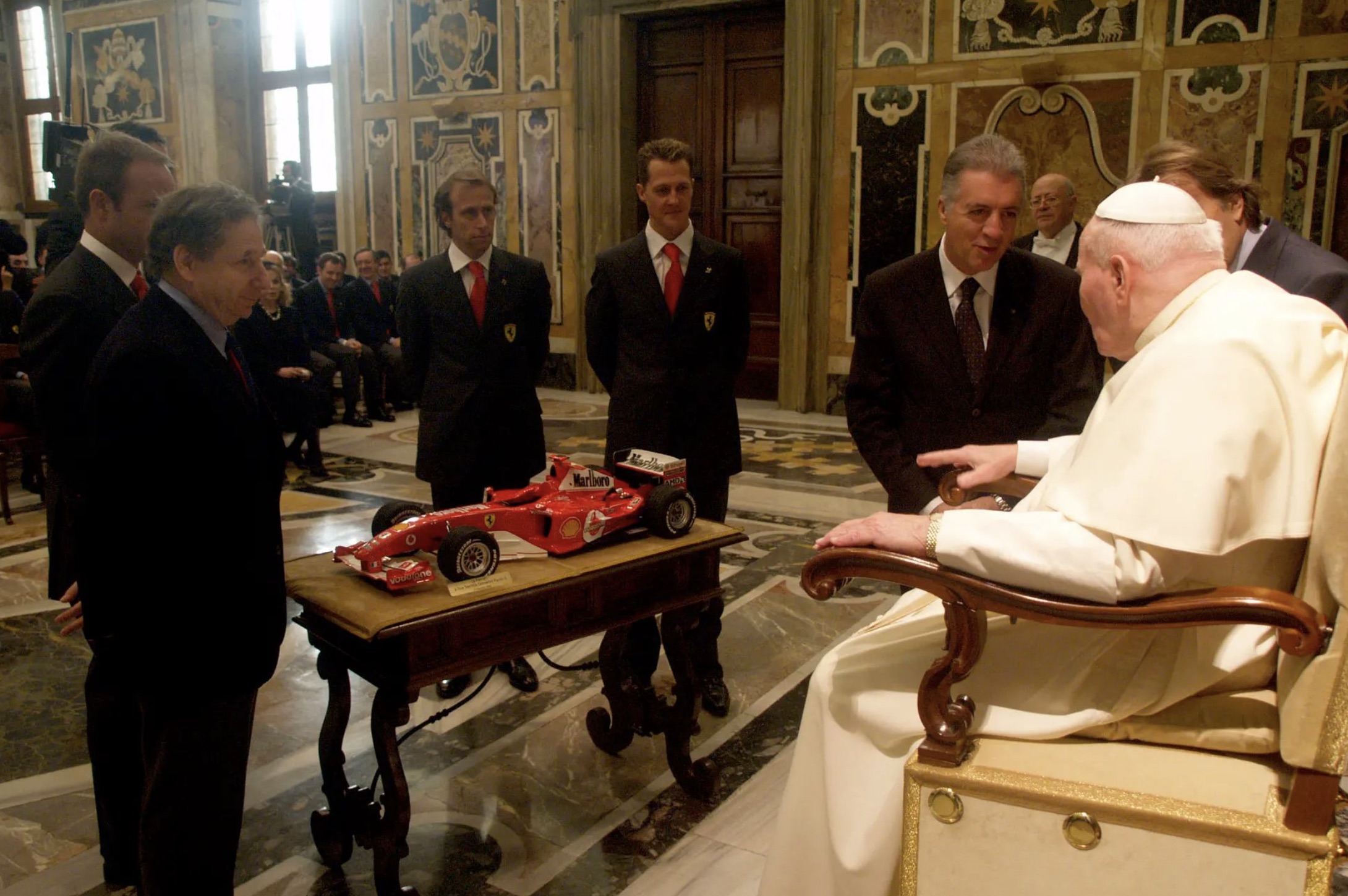 Pope John Paul II observing a model of a Ferrari race car 